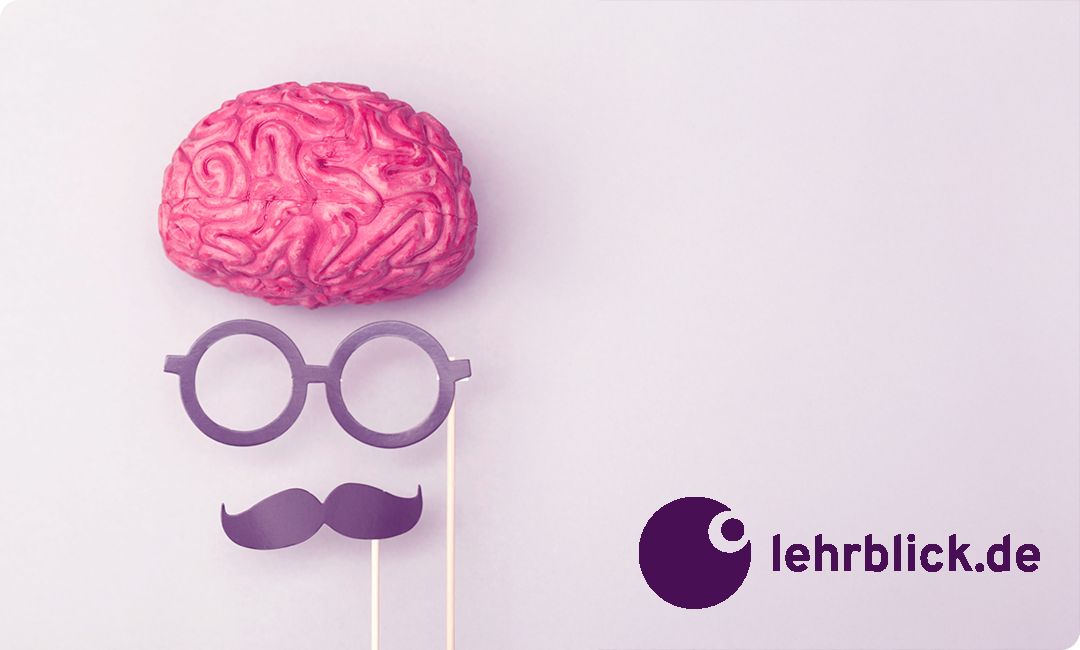 Modell eines rosa Gehirns über einer Brille und einem Schnurrbart aus Papier an Stäben vor hellem Hintergrund mit Logo und Schriftzug 'lehrblick.de'