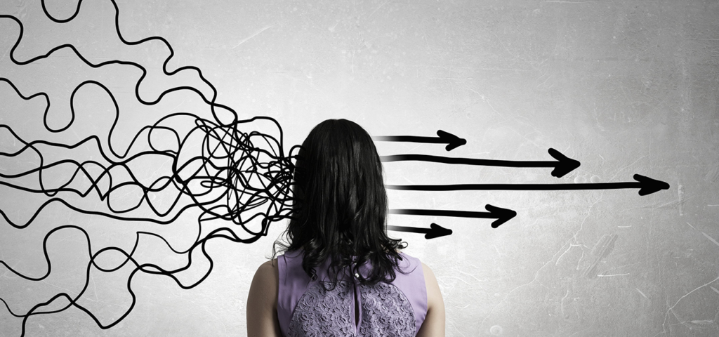 A woman seen from behind against a wall with jumbled lines on the left and straight arrows on the right