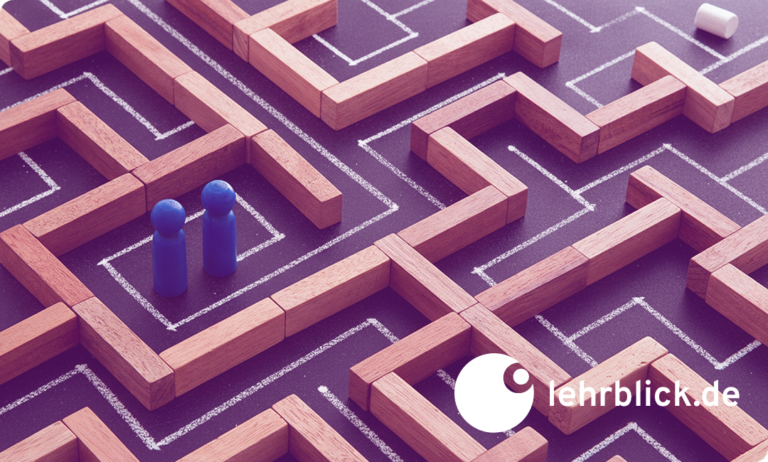 Holzlabyrinth mit zwei blauen Spielfiguren auf einem Wegabschnitt und dem Logo von lehrblick.de